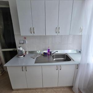 a kitchen with white cabinets and a sink at Happy House Garden in Plovdiv