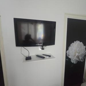 a flat screen tv hanging on a white wall at Happy House Garden in Plovdiv +13 photos