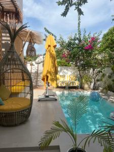 a swimming pool with a chair and a yellow umbrella at Palms hotel and Spa in Fulhadhoo