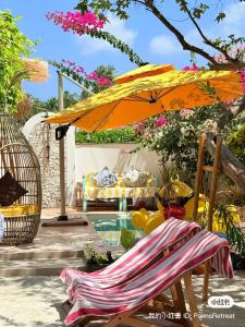 a patio with an umbrella and a chair and a pool at Palms hotel and Spa in Fulhadhoo