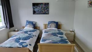 a bedroom with two beds and a painting on the wall at B-SIDE Loppem in Zedelgem