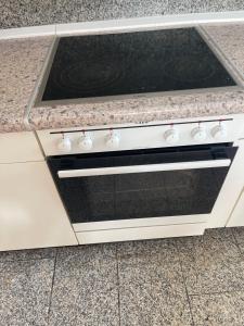 a white stove top oven in a kitchen at Ferienwohnung Habichtswald in Habichtswald