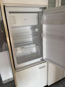 an empty refrigerator with its door open in a kitchen at Ferienwohnung Habichtswald in Habichtswald