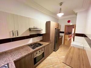 a kitchen with a stove and a refrigerator at Reco flores PALM in Ben Slimane