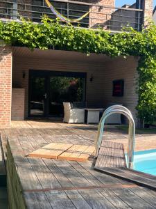 a swimming pool with a faucet on a patio at Chez Maïlis in Rhisnes