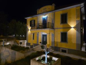 a large yellow building with a balcony at night at Vila Dara 1924 in Tivat