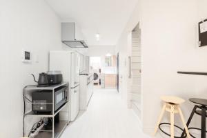 a white kitchen with white floors and white walls at 一軒家貸切 THREE FIELD Kobe Nakayamate in Kobe