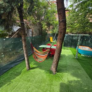a hammock hanging between two trees in a yard at Happy House Garden in Plovdiv