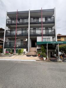 an apartment building with a staircase in front of it at Gallery Compass- Art Apartments Osaka with Breakfast Free Parking in Osaka