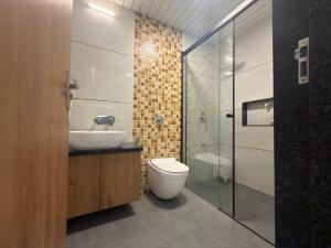 a bathroom with a toilet and a sink and a shower at Bungalow Seven Mount Abu in Mount Ābu