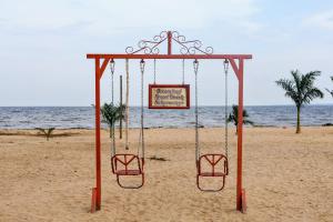 a swing on the beach with a sign on it at Dream Land Resort Beach in Mpigi