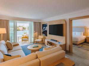 a hotel room with a couch and a bed at Hamilton Princess & Beach Club A Fairmont Managed Hotel in Hamilton