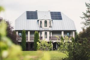a house with solar panels on the roof at Ezernieki in Valka +11 photos
