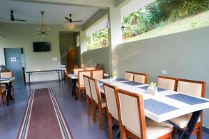 a dining room with a long table and chairs at Skyleaf Resort in Meenangadi