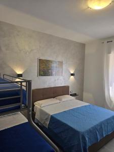a bedroom with a bed with a blue comforter at Gli Amici della Puglia 2 in Taranto