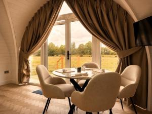 a dining room with a table and chairs in front of a window at Leisure Lodges in Glastonbury
