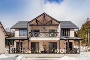 a large house with a black roof at HOPETREE HAKUBA in Hakuba