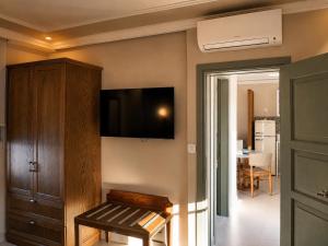 a room with a tv on the wall with a bench at Athena Collection in Kefalos