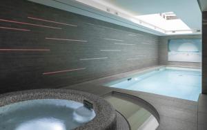 a jacuzzi tub in a room with a television at BW Premier Collection Le Saint Antoine Hotel et Spa in Rennes