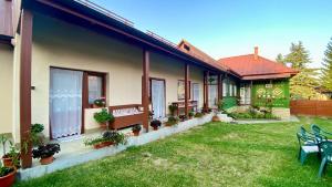 a house with a yard with chairs and plants at Golyafeszek Vendeghaz in Sîncraiu