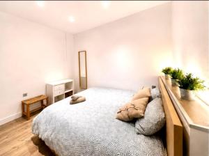 a white bedroom with a large bed with pillows at CasaGerman in Sierra Nevada