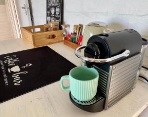a coffee maker with a green coffee cup in it at Pebbles & Shells in Kleinmond +12 photos