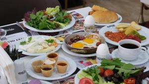 a table with plates of food and cups of coffee at Alsancak Prime Hotel Konya in Yazır