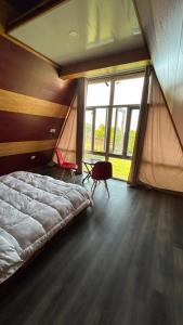 a bedroom with a large bed and a large window at Raiyar Resort doodhpathri in Rengazabal