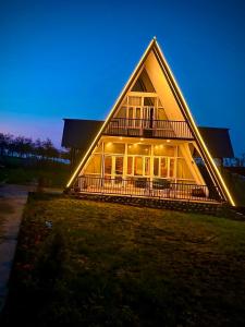a large house with a lit up facade at night at Raiyar Resort doodhpathri in Rengazabal