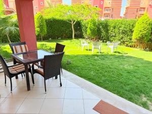 a patio with a table and chairs and a lawn at Jhvfgt in Dawwār al Ḩajj Aḩmad