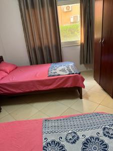 a bedroom with a bed and a window and two mats at Jhvfgt in Dawwār al Ḩajj Aḩmad