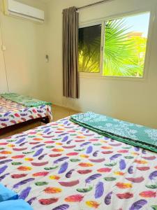 a bedroom with two beds and a window at Jhvfgt in Dawwār al Ḩajj Aḩmad