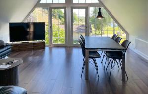 a dining room with a table and chairs and a tv at Penthouse in Hobro