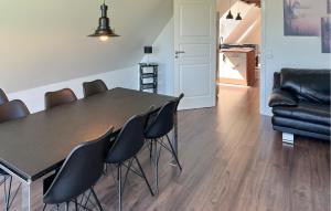 a dining room with a black table and chairs at Penthouse in Hobro