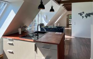 a kitchen with white cabinets and a wooden counter top at Penthouse in Hobro