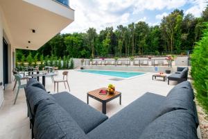 a patio with a couch and tables and a pool at Asterias Residence - New Opening 2026 in Rovinj