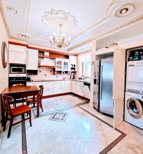 a kitchen with white cabinets and a table and a refrigerator at Villa Eternity in Jūrmala