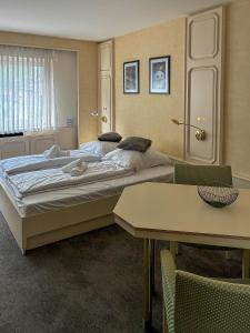 a bedroom with a large bed and a table at Hotel ALMA in Wassenberg +20 photos