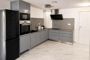 a kitchen with a black refrigerator and a stove at Luxury Beachfront Family Apartment in La Pineda