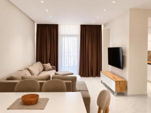 a living room with a couch and a tv at Adan Luxury Aparthotel in Orikum