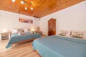 a bedroom with two beds and a wooden ceiling at Apartment Dinka in Kornić