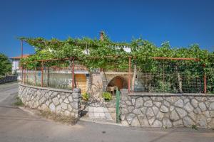 a building with a stone wall with vines at Apartment Dinka in Kornić