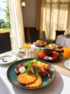 a table with a plate of breakfast food on it at Hotel Golden Palace in Göd