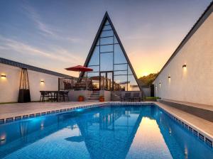 a swimming pool in front of a building at Qafqaz Front Falcon Chalet in Gabala
