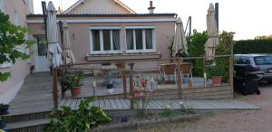 a house with a deck with chairs and umbrellas at Villa Varco in Auxonne