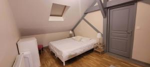 a small bedroom with a white bed and a door at Villa Varco in Auxonne