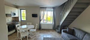 a small living room with a table and a kitchen at Villa Varco in Auxonne