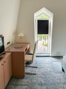 an office with a desk and a chair and a window at Hotel ALMA in Wassenberg