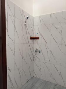 a bathroom with white marble walls and a shower at Le Charme Pakbeng Villa in Pakbeng