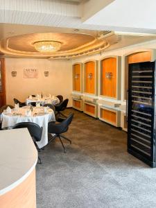 a dining room with tables and chairs and a chandelier at Hotel ALMA in Wassenberg